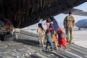 یک خانواده افغان در حال ورود به هواپیمای نظامی آمریکا