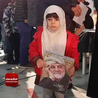 عکس شهید حاج قاسم سلیمانی در دستان کودک حاضر در شعبه اخذ رای   
