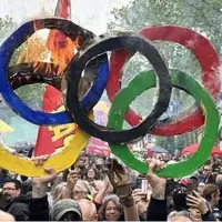 عکس/ به آتش کشیدن حلقه‌های المپیک در تظاهرات روز کارگر پاریس!
