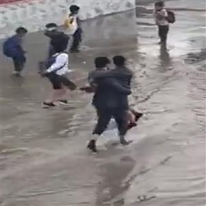 تصاویری از فداکاری معلم مشهدی برای عبور دانش‌آموزان از جریان سیل