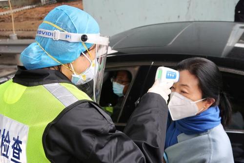 کنترل تب مسافران در شهر شیانینگ چین برای اطلاع از ویروس کرونا