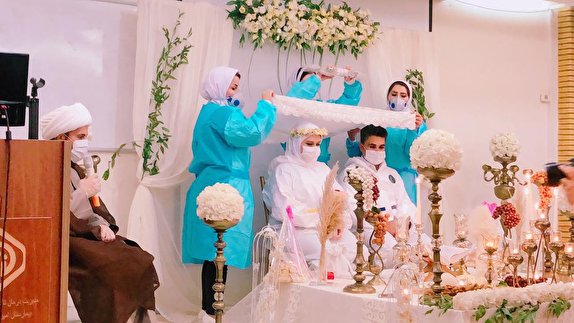 زوج پرستاری که با لباسی عجیب پای سفره عقد نشستند