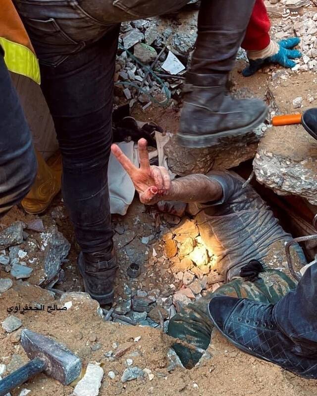 عکس/ علامت پیروزی یک فلسطینی از زیر آوارها