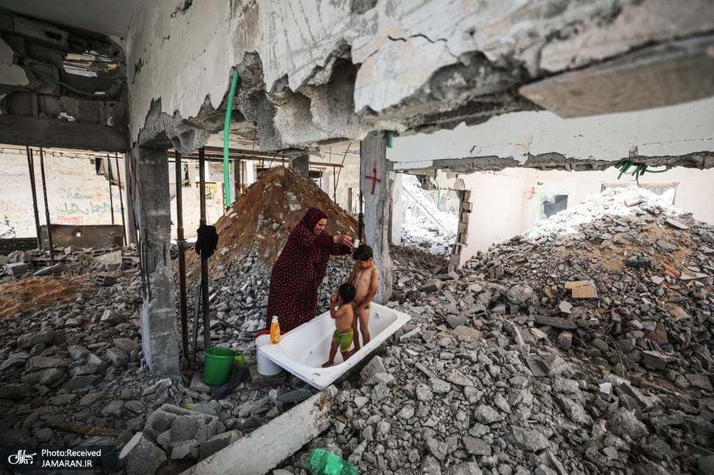 حمام کردن دو کودک فلسطینی در میان آوارها