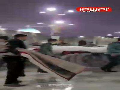 کمک زائران به خدام حرم مطهر رضوی در هنگام باران