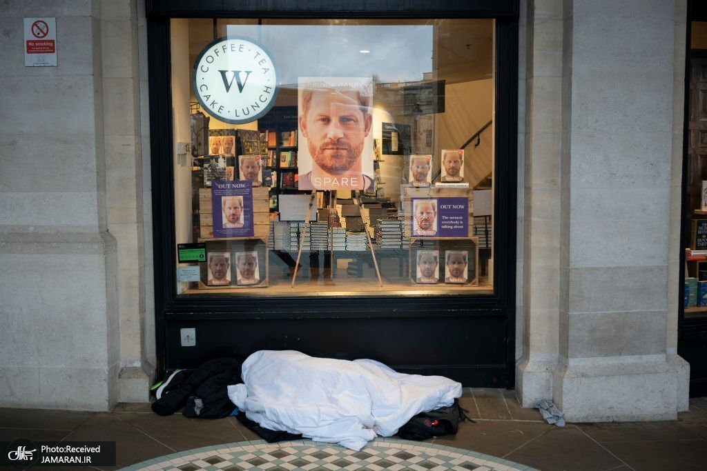 تصویری معنادار از خواب یک بی خانمان زیر ویترین یک کتابفروشی در لندن