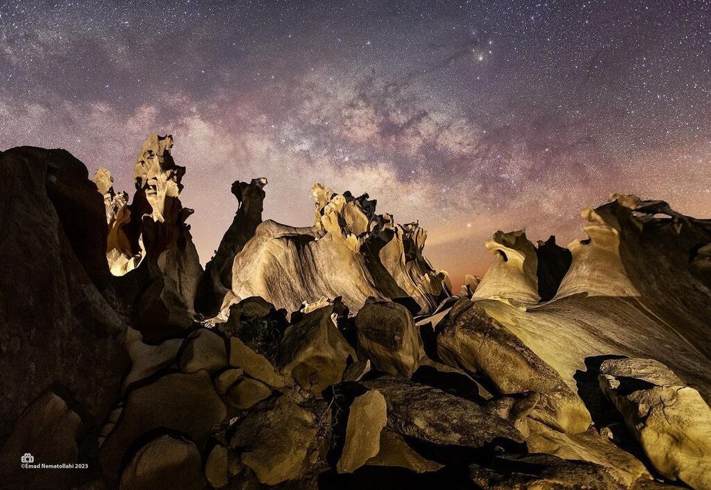 تصویر کهکشان راه‌شیری بر فراز صخره‌های ساحل مُکَسّر