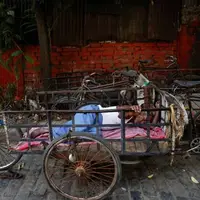 خواب ظهرگاهی باربر هندی درون سه چرخه در شهر کلکته