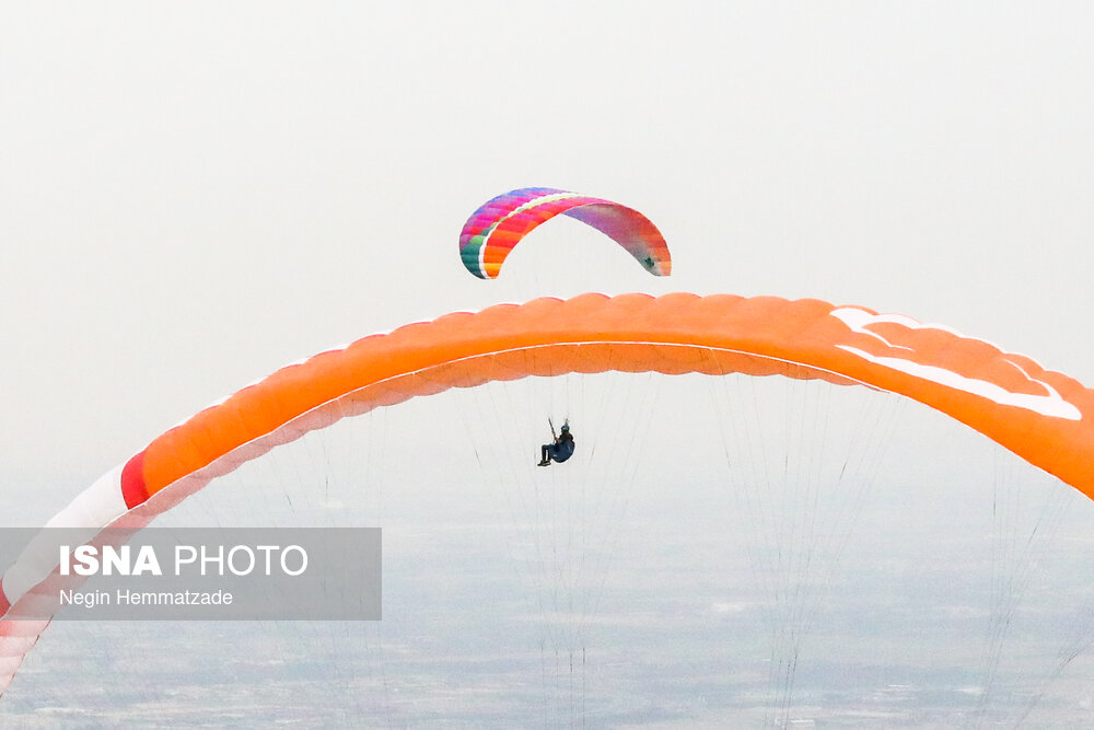 عکس/ پرواز با بال‌های پارچه‌ای در مجاورت دریاچه چیتگر