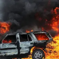 تلاش مردم برای نجات سرنشین یک خودروی آتش گرفته