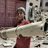 بقایای موشک شلیک شده توسط رژیم صهیونیستی در دستان پسر فلسطینی