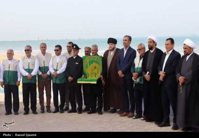 اهتزاز پرچم حرم رضوی به دست خدام در سواحل خلیج فارس بوشهر