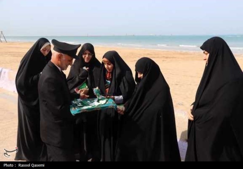 اهتزاز پرچم حرم رضوی به دست خدام در سواحل خلیج فارس بوشهر