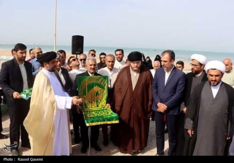 اهتزاز پرچم حرم رضوی به دست خدام در سواحل خلیج فارس بوشهر