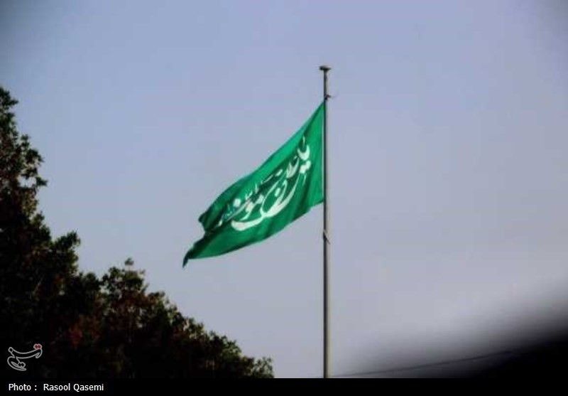 اهتزاز پرچم حرم رضوی به دست خدام در سواحل خلیج فارس بوشهر