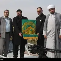 اهتزاز پرچم حرم رضوی به دست خدام در سواحل خلیج فارس بوشهر