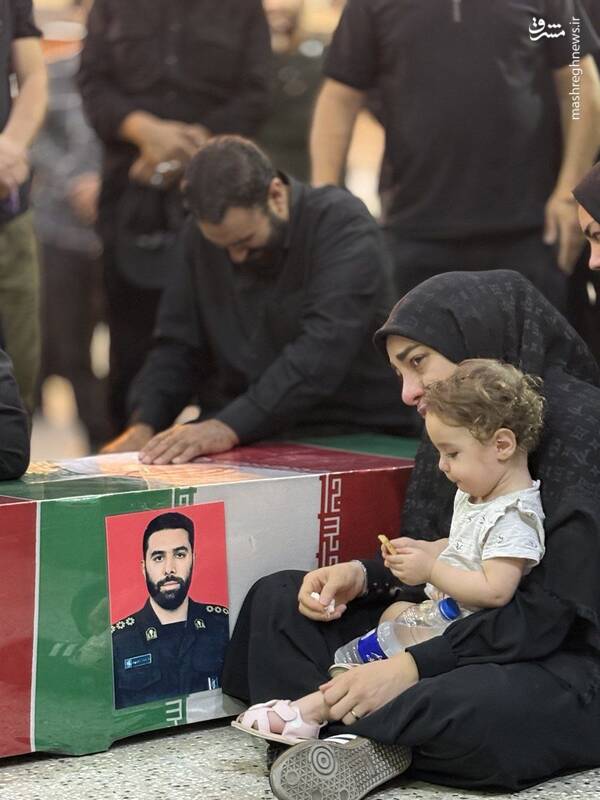 عکس/ همسر و فرزند شهید رامین نصیری در کنار پیکر شهید