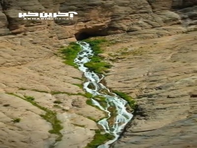 چشمه ای زیبا از درون یک غار در دل کوه