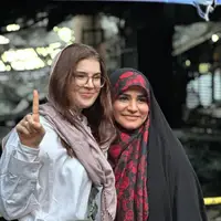 عکس/ عکس خبرنگار آمریکایی با سحر امامی در کنار ساختمان شیشه‌ای