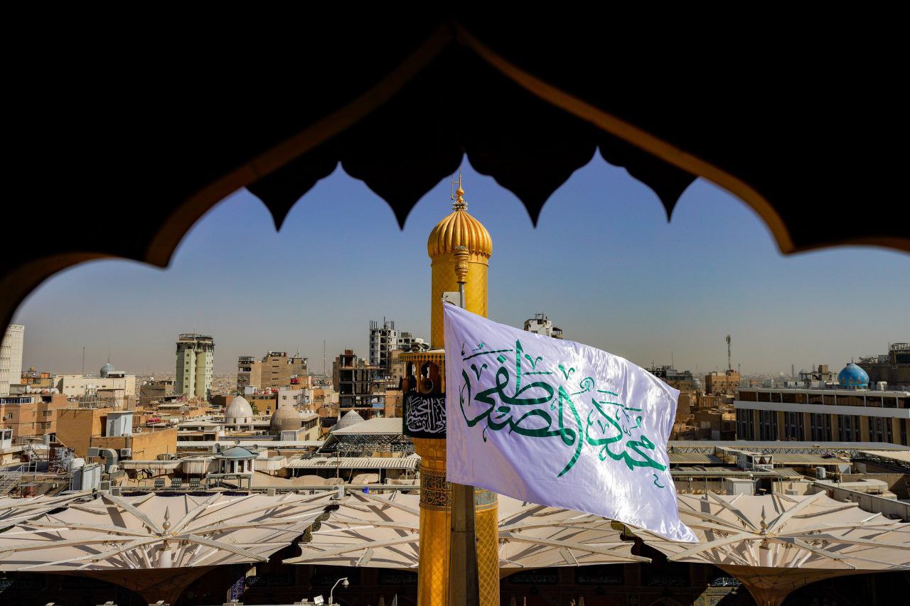 عکس/ برافراشتن پرچم پیامبر اکرم(ص) در حرم امام علی(ع) به مناسبت هفته صادقین