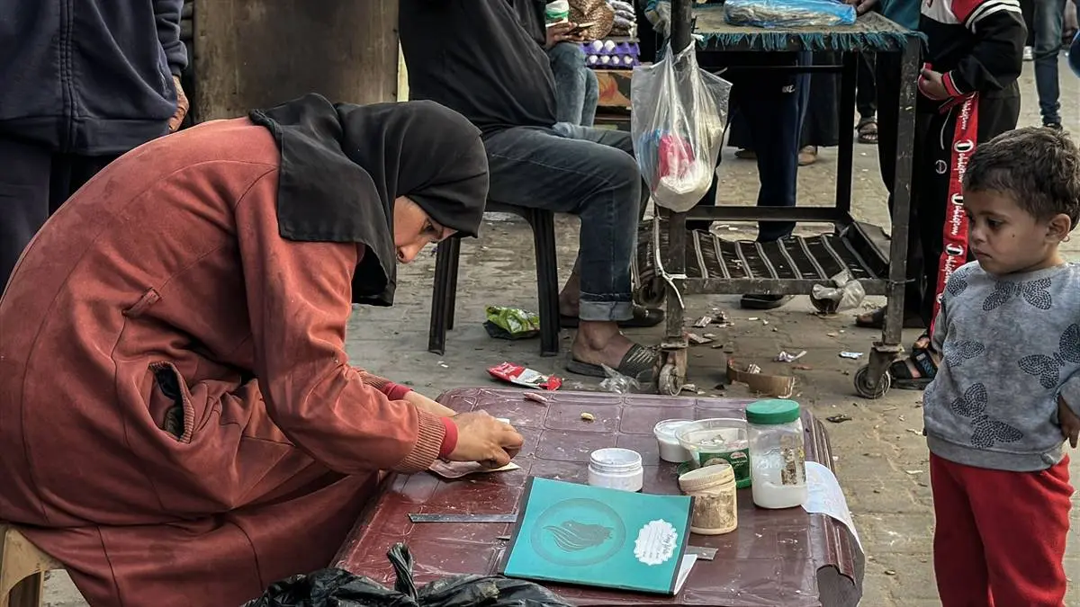 تصاویر زن فلسطینی که با ترمیم اسکناس‌های پاره امرار معاش می‌کند!